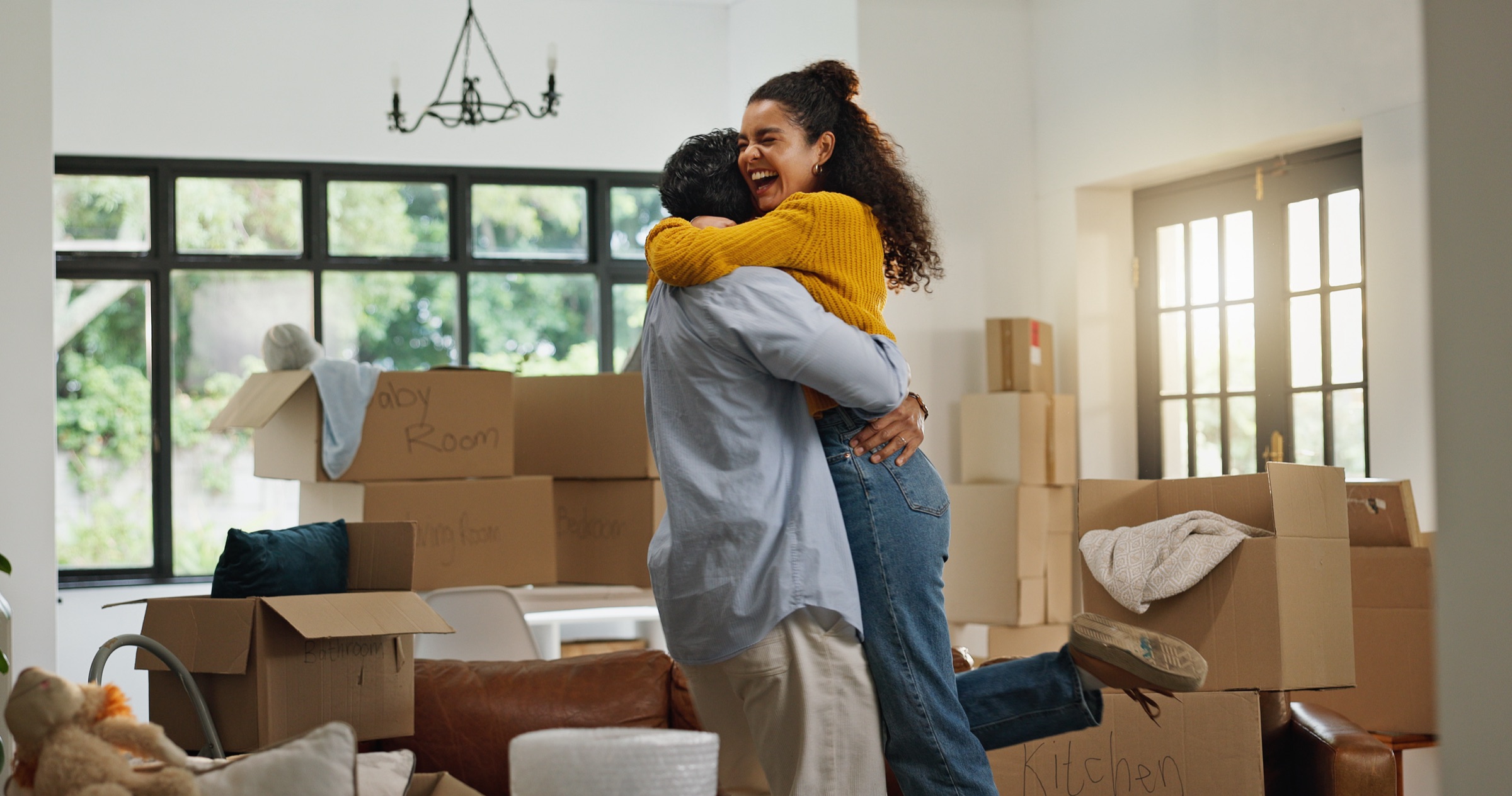 A couple embracing among moving boxes in their new home
